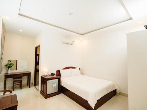 a white room with a bed and a desk and a bed sidx sidx at NAM CẦN THƠ HOTEL in Ấp Phú Thạnh (4)