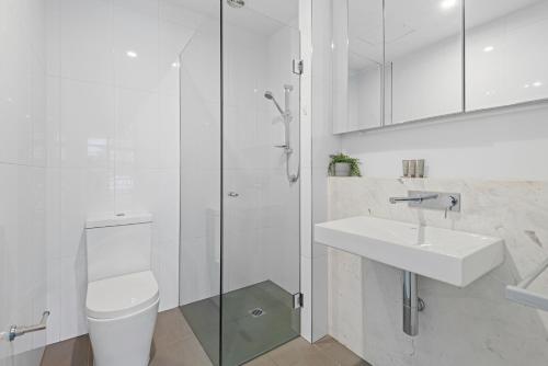 a bathroom with a toilet and a sink and a shower at Newly Refurnished Beachside 1-Bedroom Apartment in Melbourne