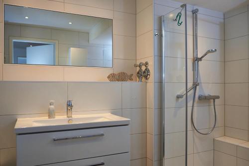 La salle de bains est pourvue d'un lavabo et d'une douche avec un miroir. dans l'établissement STRANDPERLE - 73513, à Eckernförde