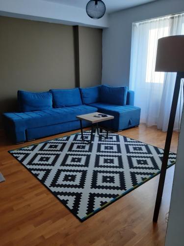 a living room with a blue couch and a rug at Modern Living Apartments in Skopje