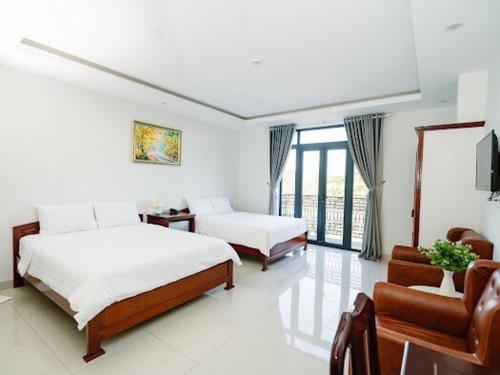 a hotel room with two beds and a couch at NAM CẦN THƠ HOTEL in Ấp Phú Thạnh (4)