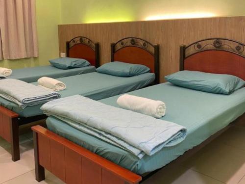 3 Single Bed with Private Bathroom في كوالا برليس: ثلاثة أسرة في غرفة بها