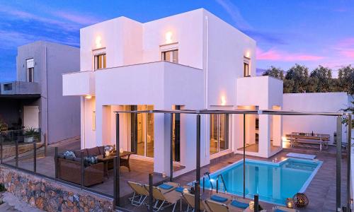 a large white house with a swimming pool at Cretan Sunset Villa Heated Pool in Dhrámia