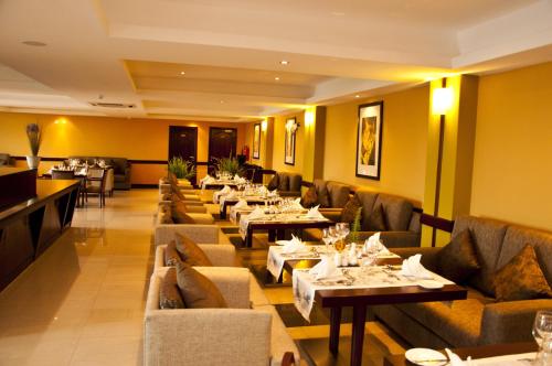a restaurant with couches and tables in a room at Gorillas Golf Hotel in Kigali