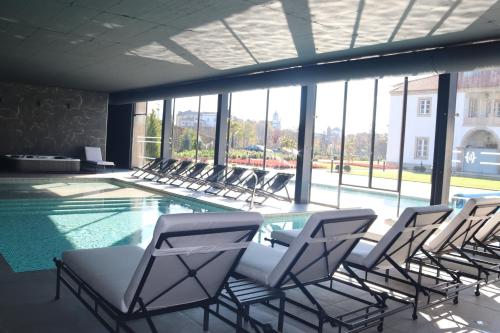 um grupo de cadeiras sentadas em torno de uma piscina em Solar do Requeijo by Luna Hotels & Resorts em Arcos de Valdevez