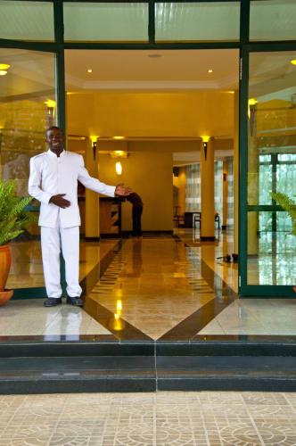 a man in a white suit standing in a lobby at Gorillas Golf Hotel in Kigali