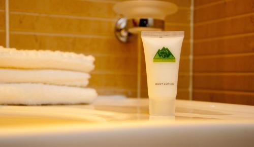 a bottle of lotion sitting on top of a bathroom sink at Gorillas Golf Hotel in Kigali
