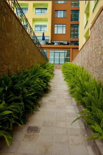 a hallway of plants in front of a building at Gorillas Golf Hotel in Kigali