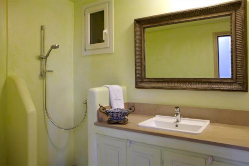W łazience znajduje się umywalka, lustro i prysznic. w obiekcie Diles & Rinies w mieście Tinos