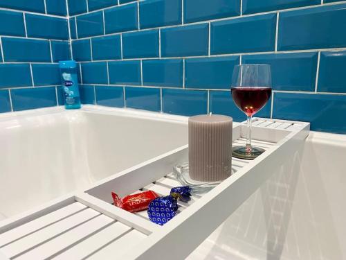 a bottle of wine and a glass of red wine at City Centre Apartment Northampton in Northampton