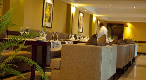 a dining room with a long table and chairs at Gorillas Golf Hotel in Kigali