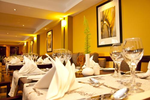 a dining room with a table with wine glasses at Gorillas Golf Hotel in Kigali