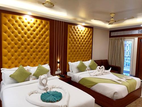 ein Hotelzimmer mit 2 Betten und einem gelben Kopfteil in der Unterkunft Hotel Morning Glow in Digha