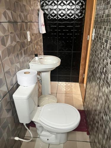 a bathroom with a toilet and a sink at Edicula Fundos in Jordãozinho