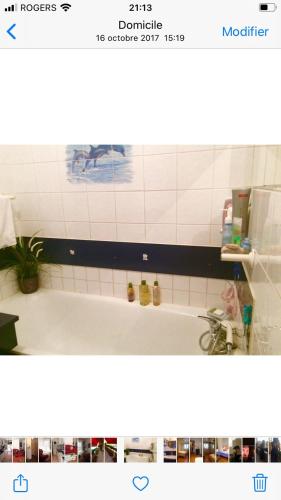 ein Badezimmer mit einer Badewanne und einer weißen Kachelwand in der Unterkunft Bel appartement très bien situé avec place de parking in Marseille