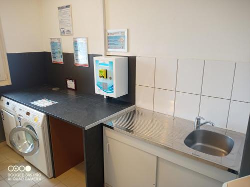 eine Küche mit einer Spüle und einer Waschmaschine in der Unterkunft Bergheim Piscine in Bergheim