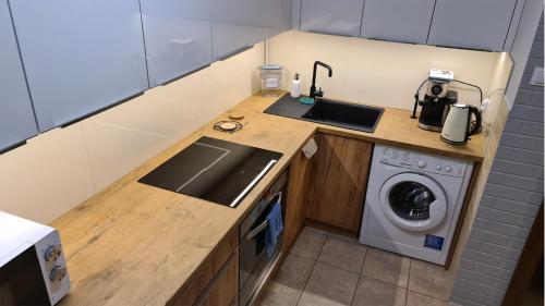 a kitchen with a sink and a washing machine at Spokojny Wypoczynek 4 in Ostrów Wielkopolski