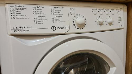 a white washer and dryer in a room at Spokojny Wypoczynek 4 in Ostrów Wielkopolski