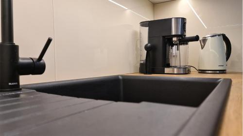 a kitchen sink with a coffee maker on a counter at Spokojny Wypoczynek 4 in Ostrów Wielkopolski