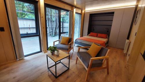 Habitación pequeña con cama, mesa y sillas en Monoambiente cálido y modernoso con amplio jardín en el centro de SMA. 2V5 en San Martín de los Andes