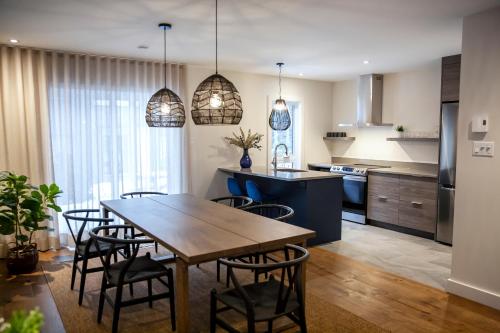 a kitchen and dining room with a wooden table and chairs at Condos Kamik Tremblant in Mont-Tremblant