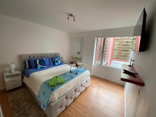 um quarto com uma cama grande e uma janela em Rep del Salvador, Quito 1-bedroom condo with parking and Netflix em Quito
