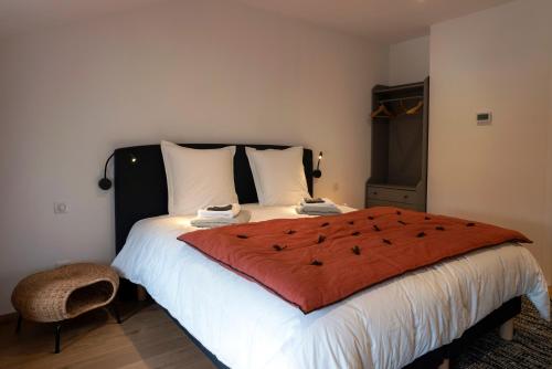 a bedroom with a large bed with a red blanket at Gîte Bellene Villa de vos Rêves in Beaune