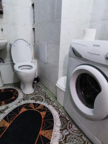 uma casa de banho com um WC e uma máquina de lavar roupa em X,ata 2 em Almaty