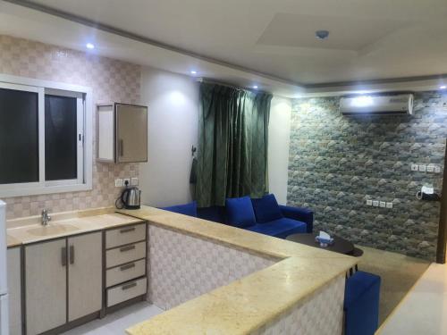 a room with a kitchen with a sink and a couch at برج الياسمين 2 in Riyadh