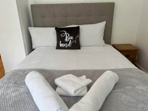 - un lit avec des serviettes blanches et un oreiller noir dans l'établissement Entire Flat in Euston-Kings Cross, à Londres
