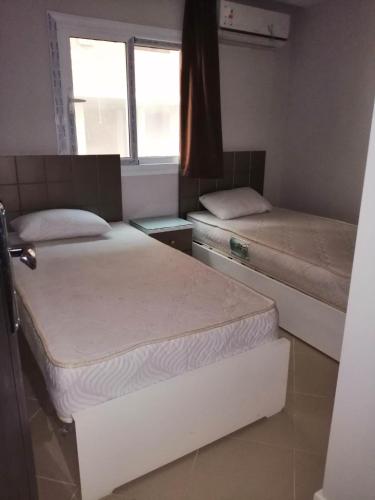 two beds in a room with a window at 101 b in Hurghada