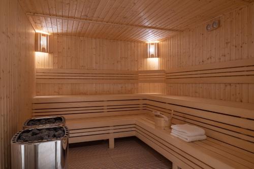 a wooden sauna with a bench and towels in it at Shaden Resort in AlUla