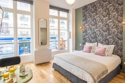 ein Schlafzimmer mit einem großen Bett und einem Spiegel in der Unterkunft Cosy Studio in the heart of Belleville in Paris