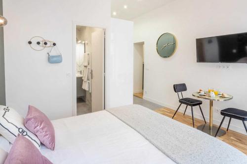 a bedroom with a bed and a tv on a wall at Cosy Studio in the heart of Belleville in Paris