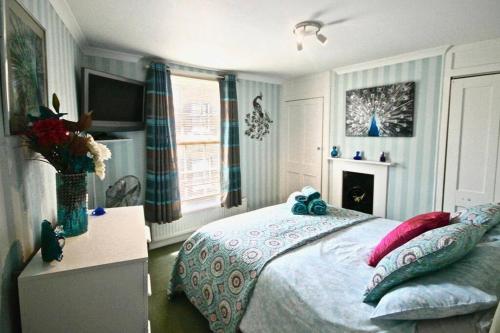 een slaapkamer met een bed met een blauwe boog erop bij Pebbles in Deal