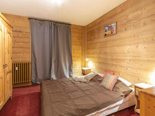 a bedroom with a bed in a room with wooden walls at Appartement Sud au Centre - 6 pers., balcon, cuisine équipée - FR-1-694-125 in Val dʼIsère