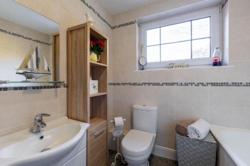 a bathroom with a sink toilet and a window at Leatside Cottage in Dulverton