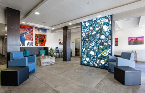 a lobby with a large glass door with blue chairs at Hotel Elev8 Flagstaff I-40 Exit 198 Butler Ave in Flagstaff