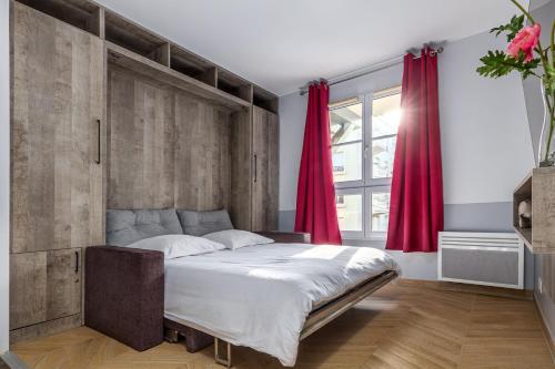 a bedroom with a large bed with red curtains at Disneyland Appartements familial avec piscine intérieur chauffé, parking gratuit A 5 minutes des parcs in Serris