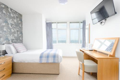 a bedroom with a bed and a desk with a computer at Hotel Santa Maria - formerly Daishs Blackpool in Blackpool