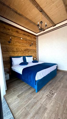 a bedroom with a blue bed with a wooden wall at Harsnadzor Eco Resort in Halidzor