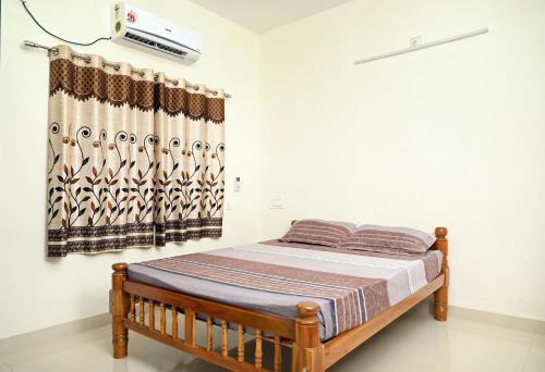 a bedroom with a bed and a curtain at VENUS HOMES in Mangalore