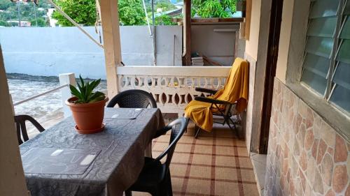 a table and chairs on a balcony with a window at Maison de 2 chambres avec jardin clos et wifi a Le Robert a 1 km de la plage in Le Robert