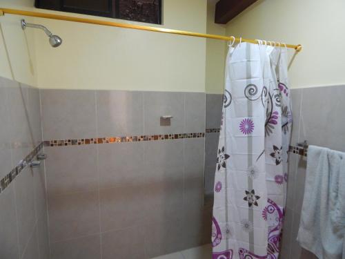 a shower with a shower curtain in a bathroom at Comodo y centrico in Ambato