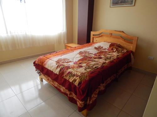 1 dormitorio con 1 cama en una habitación con ventana en Comodo y centrico, en Ambato