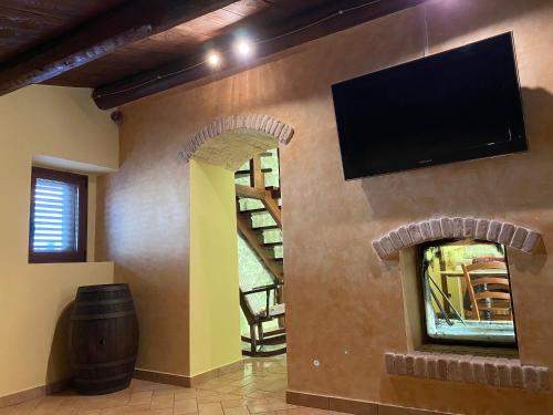 a living room with a stone fireplace with a flat screen tv at Pacentro Dimora del Castello in Pacentro
