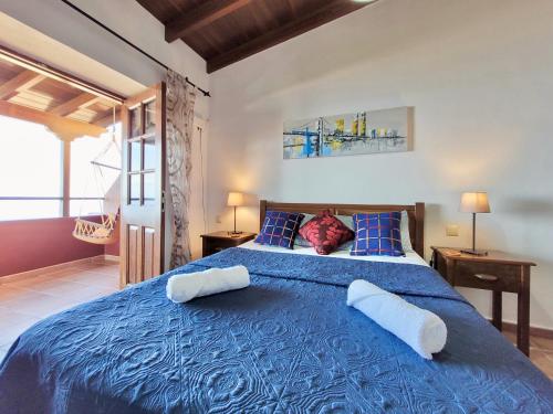 ein Schlafzimmer mit einem blauen Bett mit zwei Kissen in der Unterkunft Bollullo Sunset - Apamate in La Orotava