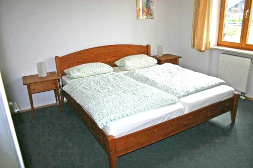 um quarto com uma cama de madeira e 2 mesas de cabeceira em Ferienwohnung Neelsen em Aschau im Chiemgau