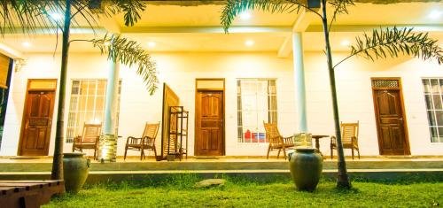 a house with chairs and a table in front of it at Inn Sea Horizon Ahungalla in Ahungalla