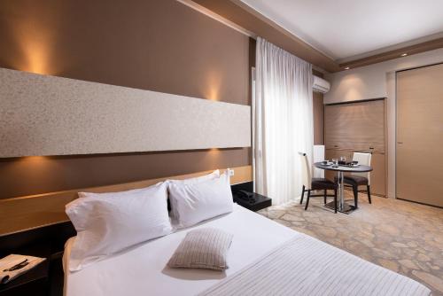 Habitación de hotel con cama y mesa en Afrodite Suites, en Potos